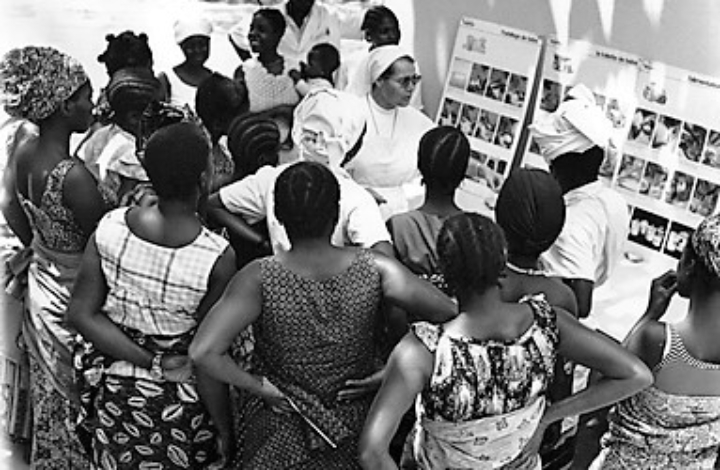 Black and white photo of a “Health talk” by a Missionary Sister of Our Lady of Africa to young African women about taking care of babies (1935). Erfgoedcentrum Nederlands Kloosterleven, AR-Z093 Archief Missiezusters van O.L. Vrouw van Afrika, BM-Z093, 116262 Black and white photo of a